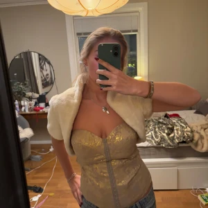 Vit fluffig bolero  - Säljer en elegant vit päls bolero från Coast. Västen har en mjuk och lyxig känsla, perfekt för att ge en stilfull touch till din outfit. Den är fodrad med ett glansigt material som ger extra komfort. Super fin till fest och att matcha med min fina korsett topp