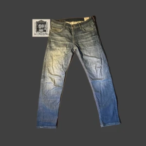 Blå Jack&Jones jeans med tapered fit 👖 - 👖Snygga blå jeans med en tapered fit som ger en modern look. Perfekta för en avslappnad stil. Jeansen är använda men i mycket gott skick utan synliga tecken på slitage. Nypris: 999 kr.👖