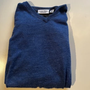 Merino ull tröja Calvin Klein  - Säljer en stilren blå tröja från Calvin Klein i extra fin merinoull. Tröjan har en v-ringad.😉 riktigt snygg och passar till alla stilar, skick 7/10✅om ni har några funderingar hör av er 👈pris är inte hugget i sten 🪨 
