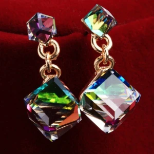 Handgjorda glittrande örhängen – Regnbågsskimrande CZ-kristaller & gyllene elegans - Glittrande handgjorda örhängen med fyrkantiga CZ-kristaller som skiftar i regnbågens färger beroende på ljus och vinkel. Perfekt för dig som älskar unika smycken med en lyxig touch! Lätta att bära och passar både till vardag och fest. Guldfärgade detaljer ger en elegant finish.  ✨ Längd: ca 2 cm ✨ Material: CZ-kristaller & metallegering ✨ Skick: Nya  Bundlerabatt!