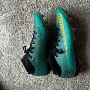 NIKE MERCURIAL SUPERFLY 6 FG CR7  - NIKE MERCURIAL SUPERFLY 6 FG CR7 CHAPTER 6. Informationen om vad den här modellen har varit med om i ronaldos karriär går att läsa på sista bilden. Detta är en sko med utseendet, historien och passformen. Aldrig varit så nöjd med ett par fotbollsskor. De är i bra skick då karriären tog slut under denna tid för mig. ( de kan användas på plan eller som en samling till cr7 retro) skorna kommer puttsas innan leverans. ((Tillverkas inte längre))