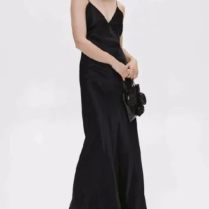 Svart långklänning  - Svart långklänning i glansigt material. Endast anvlnd en gång. Axelbanden går att sy om för önskad längd