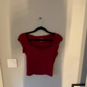 Röd topp  - Säljer en röd topp från Shein med korta ärmar och en enkel design. Perfekt för en avslappnad stil.