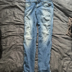 Blå jeans från Replay - Snygga blå jeans från Replay i modellen Anbass. De har en klassisk femficksdesign med slitna detaljer för en trendig look🔥🔥🔥. Perfekta för en avslappnad stil💯💯💯. Skriv om prisförslag eller eventuella frågor!