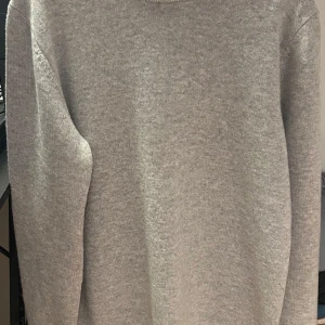 JOHN HENRIC Kashmir sweatshirt - ⚠️OANVÄNDA⚠️Säljer en stilren grå stickad tröja från John Henric. Tröjan har en klassisk design med ribbade muddar vid ärmslut och nederkant. Perfekt för kyligare dagar.