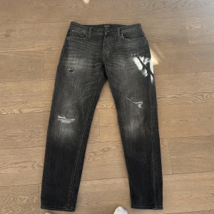 Svarta jeans med slitningar - Tjena säljer ett bara snygga Jack & Jones jeans gråa med slitningar dem är använda 1 gång storlek 32/34 har ni några frågor så är det bara att höra av sig.