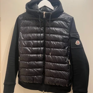 Svart jacka från Moncler - Svart moncler cardigan med huva, storlek L i dam men passar som en M på herr. Köpt på wakakuu 2021