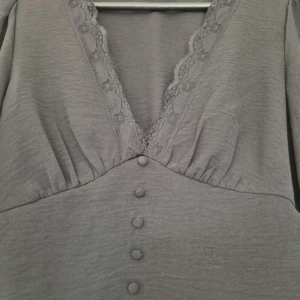 Svart blus från ONLY - Säljer en elegant svart blus från ONLY med v-ringning och spetsdetaljer. Blusen har långa ärmar och knappar framtill. Den elastiska midjan ger en smickrande passform. Perfekt för en stilren look. Går ej att förhandla, priset är fast