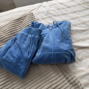 Juciy set! - Säljer juciy set i blå, använda ett par gånger och är i jättebra skick. Säljer de för att de är för stora tyvärr. Koftan är i S och byxorna i XS.💙 Använd gärna köp nu!💙skriv privat för mer bilder/frågor!