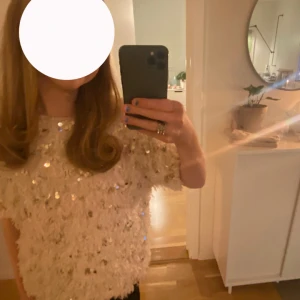 Pallijet topp - Super snygg kräm vit topp med palijetter och små fjädrar. St:164 13-14 år men passar som xs-s.