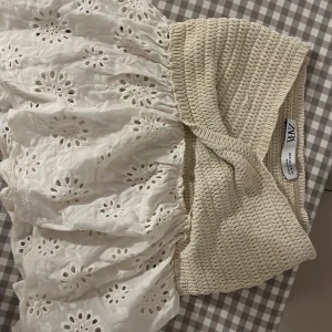 Vit topp med broderade detaljer från Zara - Topp från Zara med smockad midja och broderade blommor. Toopen har en kort modell. 