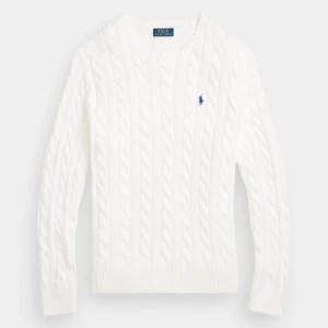 Vit kabelstickad tröja från Polo Ralph Lauren - Kabelstickad vit tröja från Polo Ralph Lauren med klassisk v-ringning och blå broderad logga på bröstet. Tröjan har långa ärmar och ribbade muddar för en tidlös look.