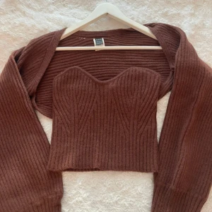 Vinröd/brun bolero set - SÄLJER DEN VINRÖDA INTE GRÅA!! Säljer en snygg bolero set med långa ärmar och en croppad passform. Toppen har en unik design med en korsettliknande stil och är perfekt för en trendig look. 