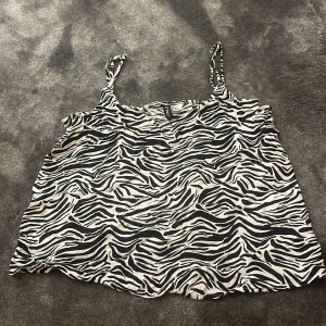 Zebramönstrad linnetopp med smala axelband - Säljer en  zebramönstrad linnetopp med smala axelband. Lätt och luftig modell som passar till många olika outfits.