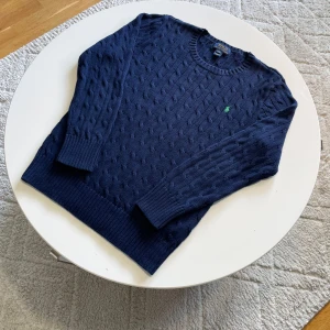Marinblå stickad tröja från Polo Ralph Lauren - Säljer en snygg marinblå stickad tröja från Polo Ralph Lauren med kabelstickat mönster🔥Tröjan har inga tecken på användning och är i nytt skick.  Nypris ca 1500 - 2000kr. Pris kan diskuteras. Följ mig gärna!!