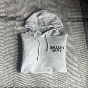 Grå hoodie från Gallery Dept. - Säljer en grå hoodie från Gallery Dept med tryck på bröstet och ryggen. Storlek S men sitter mer som M