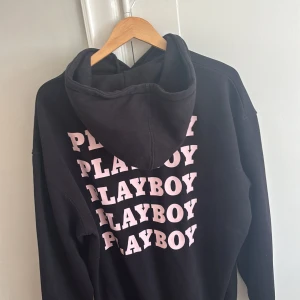 Svart hoodie från Playboy - Svart hoodie med stor huva och tryck i rosa text på ryggen. Den är stor i storleken, jag har vanligtvis S och passar. 