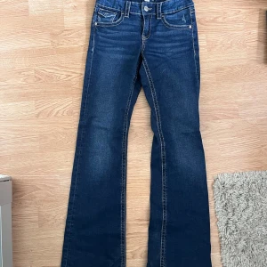 Blå bootcut jeans från Gina Tricot - Säljer ett par klassiska blå bootcut jeans från Gina Tricot i storlek 164. Används inte.