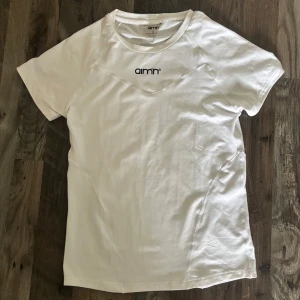 Vit tränings t-shirt från Aim'n - Säljer en vit tränings t-shirt från Aim'n med svart logga framtill. 