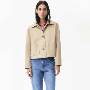 Beige trench coat - Snygg beige jacka med croppad passform och klassisk krage. Jackan har två stora fickor framtill och stängs med knappar. Perfekt för vår och höst, enkel att matcha till olika outfits.