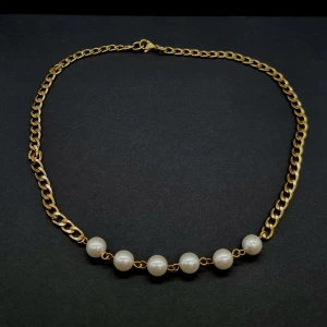 Guldfärgat halsband med pärlor - Stilrent halsband med chunky guldfärgad kedja och sju vita pärlor framtill. Längd-40cm