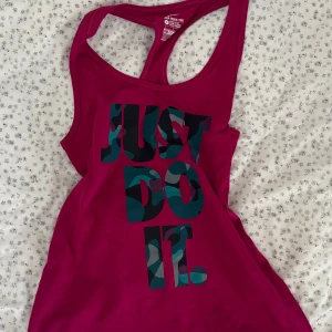 Nike träningslinne  - Säljer ett träningslinne från Nike med trycket ”JUST DO IT.” Linnet är instorlek S men passar även XS💗Linnet är DRI-FIT material