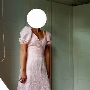 Ljusrosa kortklänning med puffärm - Supersöt ljusrosa kortklänning från & Other Stories med små vita prickar, puffiga korta ärmar och v-ringad omlott framtill🩷Storlek 36🩷