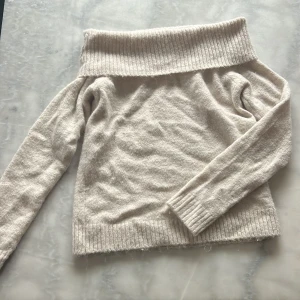 Beige offshoulder stickad tröja Gina Tricot - Supermysig beige stickad tröja från Gina Tricot med bred ribbad offshoulder-krage och långa ärmar. Perfekt för lager på lager och chill höst- eller vinterstil. Mjuk och skön känsla, passar dig som gillar en enkel men snygg look.💗💞 (användt den bara 2 gånger)