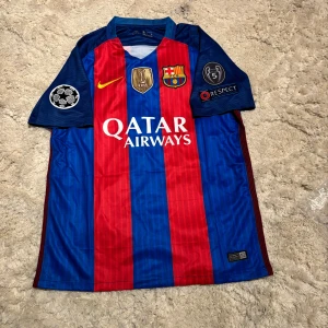 FC Barcelona Neymar Jr 11 matchtröja Nike M - Säljer en officiell FC Barcelona matchtröja från Nike med Neymar Jr och nummer 11 på ryggen. Tröjan är blå och röd med gula detaljer, klubbmärke, Champions League-patchar och Qatar Airways-tryck. Tillverkad i Dri-FIT-material som andas.