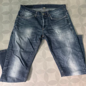 Dondup george storlek 34 - Säljer ett par blå jeans med snygga slitningar och tvättade detaljer. Klassisk femficksmodell med raka ben och kontrastsömmar. Jeansen har normal passform och är perfekta för en avslappnad stil.