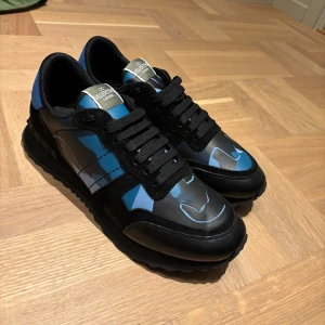 Valentino Rockrunner sneakers blå/svart - Snygga Valentino Rockrunner sneakers i svart och blått med kamouflage mönster . Perfekta för dig som vill sticka ut med stil.