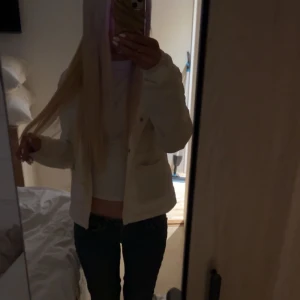 Ljusbeige pufferjacka i syntet - Säljer en ljusbeige pufferjacka med quiltad design och rund hals. Jackan har tryckknappar framtill, två fickor och är tillverkad i glansigt syntetmaterial. Perfekt för dig som gillar en clean och stilren look.några smink fläckar och lite smutsig men ska gå bort i tvätten. (Strlk 170)