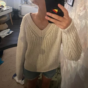 Beige stickad v-ringad tröja - Supermysig beige stickad tröja med v-ringning och breda ribbade muddar. Tröjan har en relaxed fit och långa ärmar, perfekt att slänga på sig när det är lite kyligt. Passar till jeans eller shorts för en chill look. Är du intresserad av shortsen så finns de även att köpa på min profil❤️