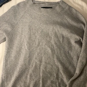 Grå stickad tröja från Vero Moda - Mysig grå stickad tröja från Vero Moda med rund halsringning och ribbade muddar. Perfekt för lager-på-lager och enkel att matcha med jeans eller kjol. Klassisk modell med lång ärm och mjukt material som känns skönt mot huden. Använd nån enstaka gång men känns verkligen som ny!