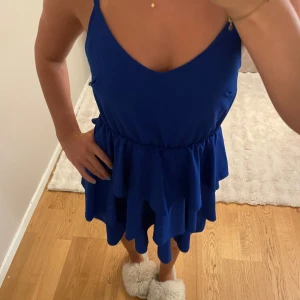 Blå volangklänning med smala axelband - Supersöt blå kortklänning med smala axelband och flera lager volanger🩷