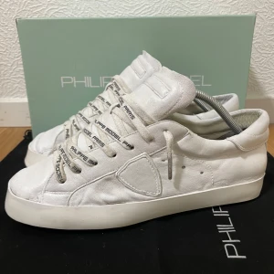 Vita Philippe Model sneakers - Snygga vita sneakers från Philippe Model i mjukt skinn med klassisk låg siluett. Skorna har vita snören med logotyp, rund tå och platt sula. Perfekta för en clean och stilren look. Storlek 43, Bra skick med en riktigt fin sula! Box medföljer! Nypris runt 3500 kr! Hör av er ifall ni har några frågor! 🙌⚜️