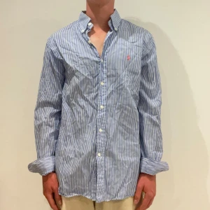 Randig Ralph lauren skjorta  - Vit/ blå randig Ralph Lauren skjorta || Storlek S (Slim Fit) || Skjortan är i bra skick || Mitt pris 599kr || Modellen på bilden är 170cm och väger 62kg || Tveka inte på att höra av dig vid frågor eller funderingar 