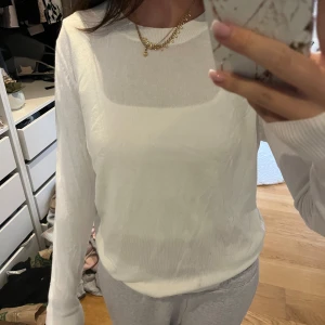 Vit tunn långärmad tröja - Säljer en vit, tunn och mjuk långärmad tröja med rund halsringning. Tröjan är enkel och stilren, perfekt att matcha med jeans eller mjukisbyxor. Materialet känns lätt och skönt mot huden.