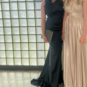 Svart långklänning med oneshoulder - Supersnygg svart långklänning med oneshoulder och öppen rygg. Klänningen har en tight passform som framhäver figuren och är perfekt för bal eller fest. Stilren och elegant design som ger en lyxig känsla. Lite defekter på släppet, finns bild. Endast använd en gång✨🪩