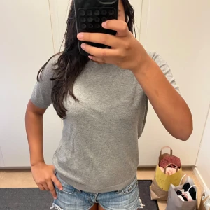 Grå basic t-shirt i bomull - Enkel och stilren grå t-shirt med korta ärmar och rund hals. T-shirten är i mjuk bomull och har en normal passform som funkar till det mesta. Perfekt för dig som gillar en clean och avslappnad look.