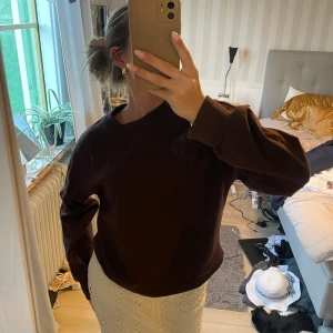 Mörkbrun oversized sweatshirt - Enkel och stilren mörkbrun sweatshirt med rund hals och långa ärmar. Tröjan har en oversized passform och breda muddar vid ärmslut och nederkant. Perfekt för en chill och avslappnad look.
