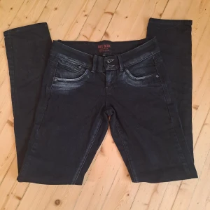 Svarta jeans från Bik Bok XS - Snygga svarta jeans från Bik Bok med slitna detaljer och dubbla knappar i midjan. Jeansen har klassisk femficksdesign, smala ben och coola sömmar på bakfickorna. Perfekta för dig som gillar en tight passform och stilren look.💗