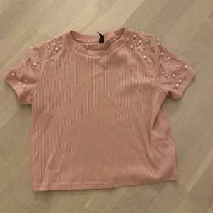 Rosa ribbad topp med pärlor H&M  - Supersöt ljusrosa ribbad topp från H&M Divided med korta ärmar och pärldetaljer på axlarna