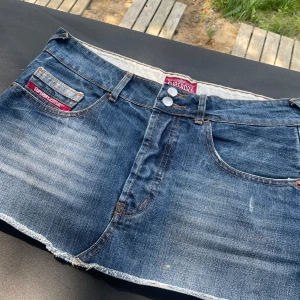 Mini Jeanskjol från Superdry  - Size is 28.= fits for M/S.     Midjematt=41cm.                                      Snygg blå jeanskjol från Superdry. Superdry-logga på fickan. Perfekt för dig som gillar en avslappnad och trendig look.