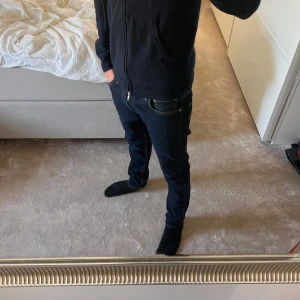 Levi's 512 mörkblå jeans W28 L30 - Säljer ett par Levi's 512 jeans i mörkblå denim. Modellen har en slim passform med raka ben och klassiska kontrastsömmar. Snygg och tidlös look med fem fickor och Levis ikoniska läderpatch bak. Perfekta för dig som gillar stilrena jeans.