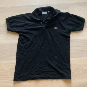 Svart pikee från lacoste - Riktigt snygg lacoste pikee passar i alla situationer, tröjan är S men passar M