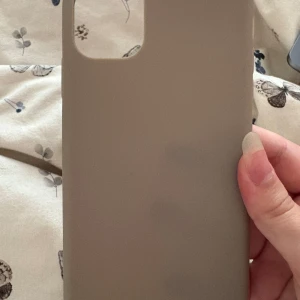Grå/brun skal iPhone 11 - Helt oanvänd skal frăn HM till IPhone 11. Den är grà brun färg. Väldigt fin