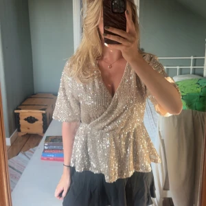 Glittrig omlottopp från Vila - Supersnygg glittrig topp från Vila i champagnefärg med omlott och v-ringning. Nyskick, storlek M ☺️
