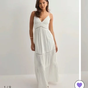 Vit långklänning med spetsdetaljer - Superfin vit långklänning med smala axelband, v-ringning och spetsdetaljer vid midjan och kjolen. Klänningen har en flowy passform och är perfekt för varma dagar. Lätt och luftig i materialet, med romantiska vibbar och snygg omlottkänsla upptill. Köpt nyligen på Nelly och är endast använd en gång och därefter tvättad. Modellen heter Maxi lace insert dress och är i storlek xs. Den är lite för liten för mig🤍