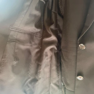 Brun klassisk kavaj med knappar - Stilren brun kavaj med två knappar framtill och klassiska slag. Fodrad insida och raka fickor med lock. Perfekt för dig som vill ha en tidlös och snygg look. Passar lika bra till skjorta som t-shirt.